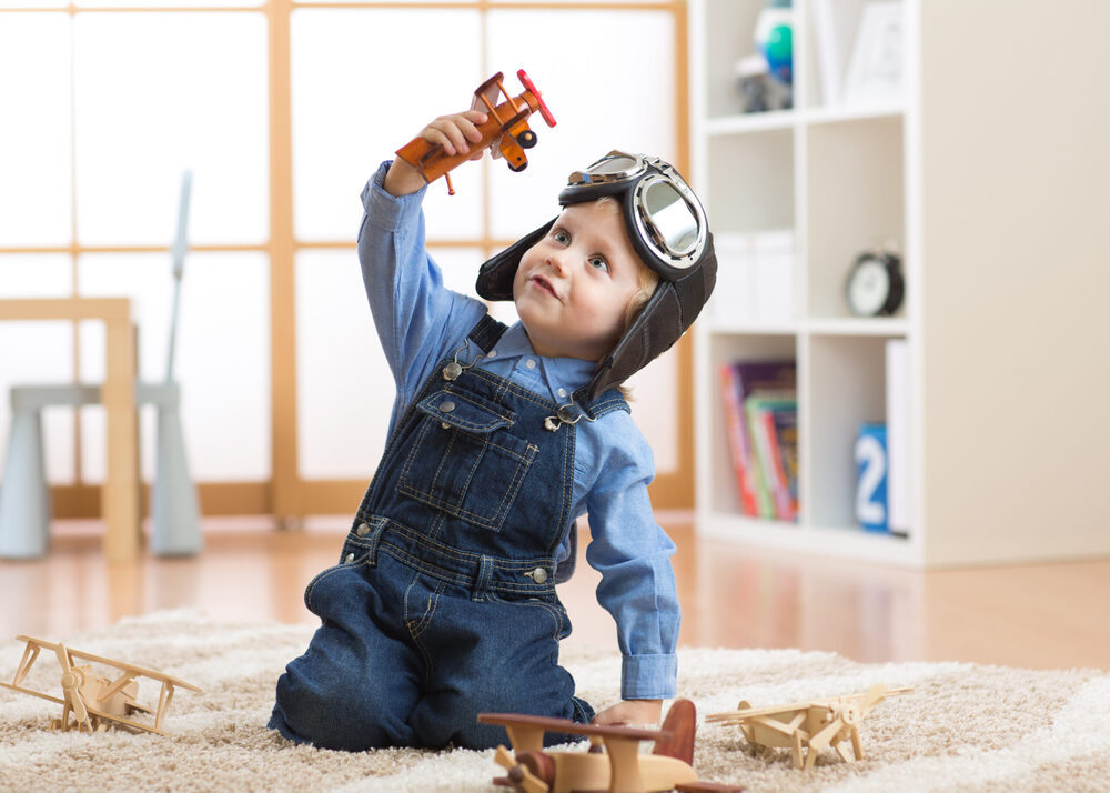 kid playing with toy planes