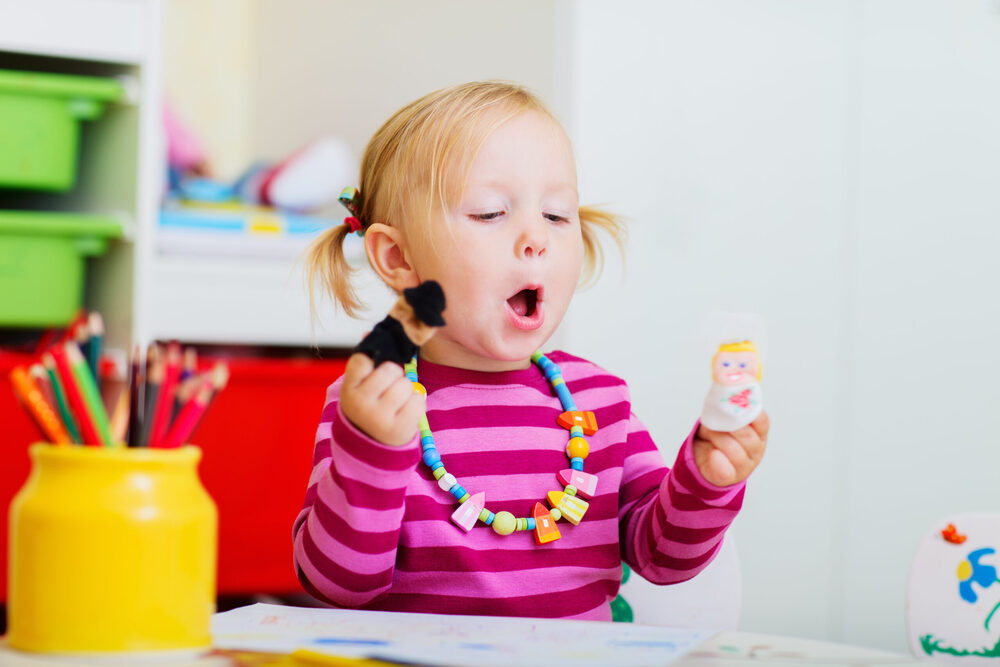 girl playing with finger puppets