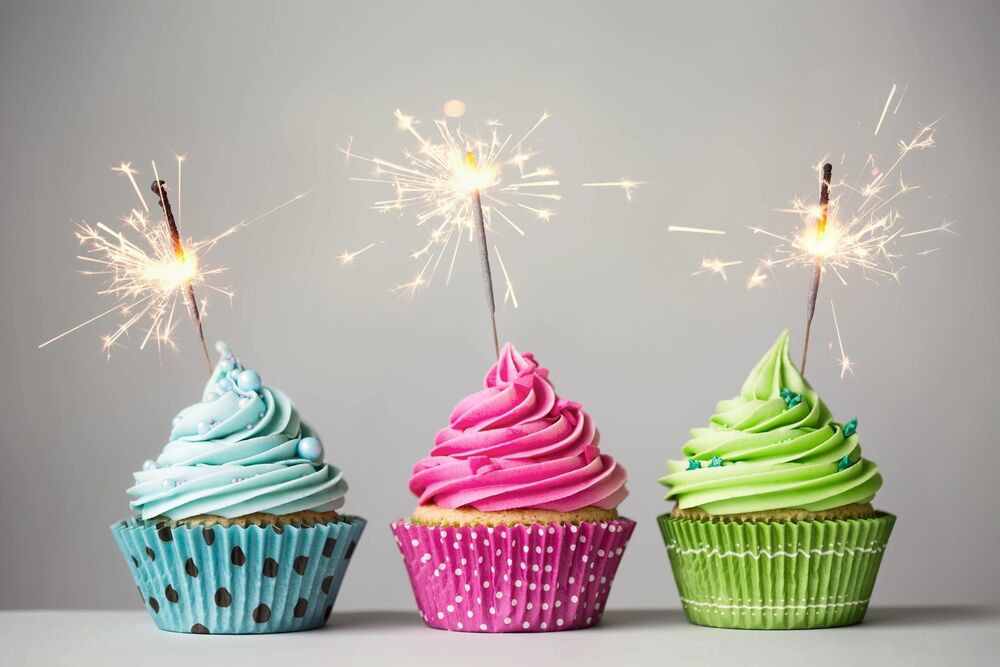 3 cupcakes with lit candles