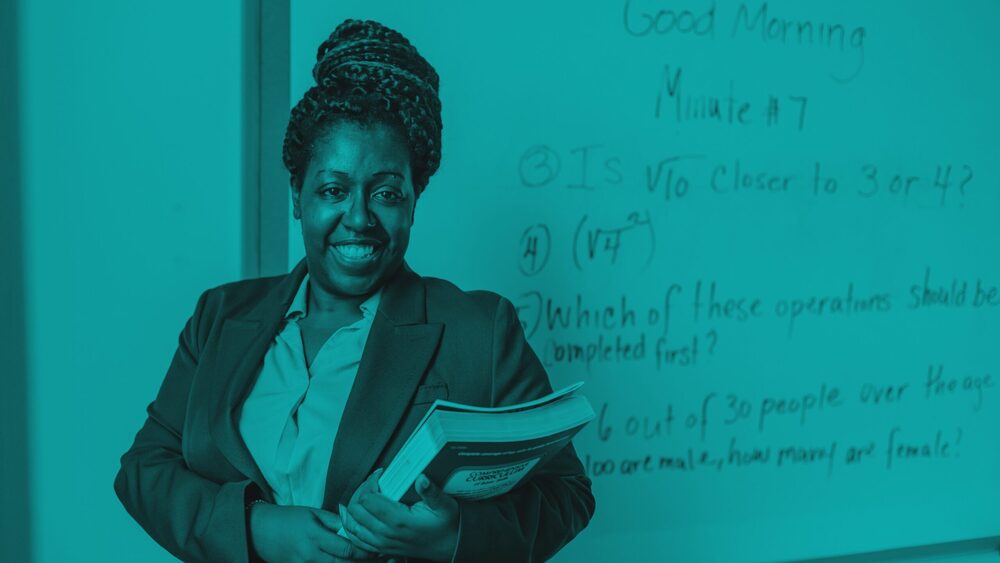 Smiling teacher holding a textbook in front of a whiteboard with math equations, styled with a monochromatic teal overlay.