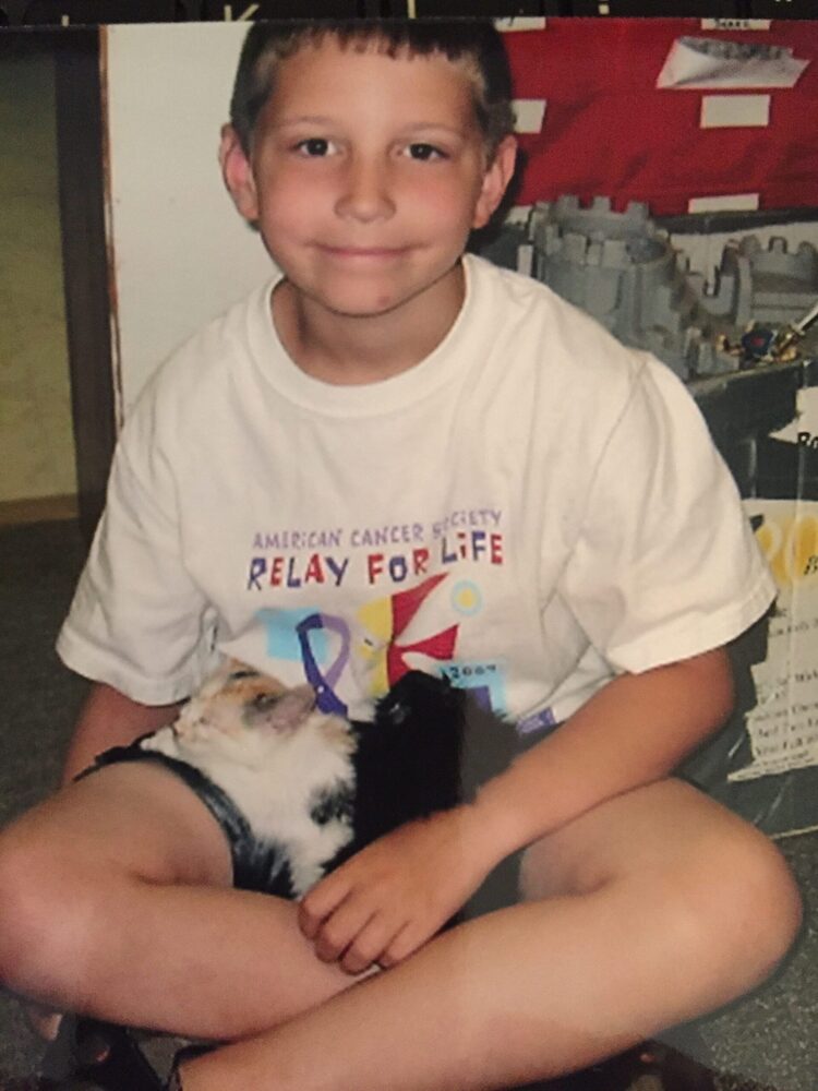 smiling kid with cat on his lap