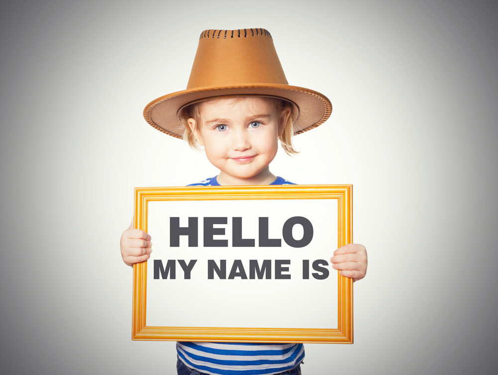 kid holding a sign that says "Hello My Name Is"