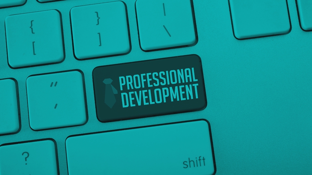 A close-up of a keyboard where the Enter key is dark and reads "PROFESSIONAL DEVELOPMENT" next to a necktie icon, styled with a monochromatic teal overlay.