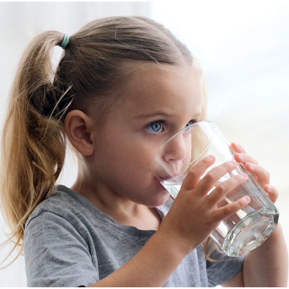 PreK girl drinking a glass of water