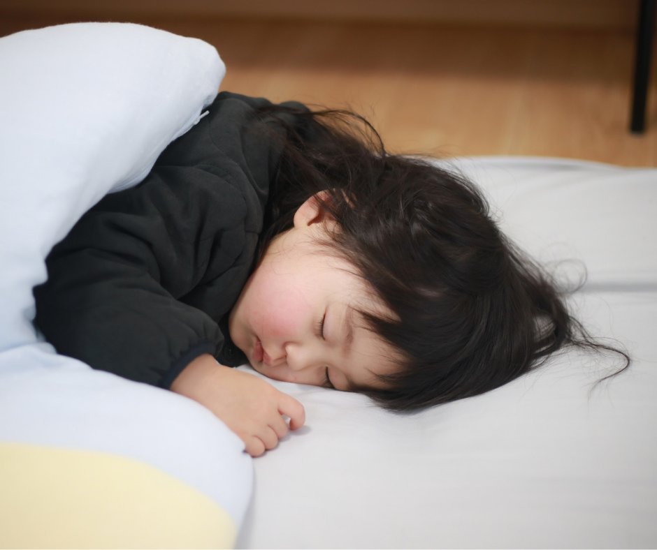small child asleep on bed