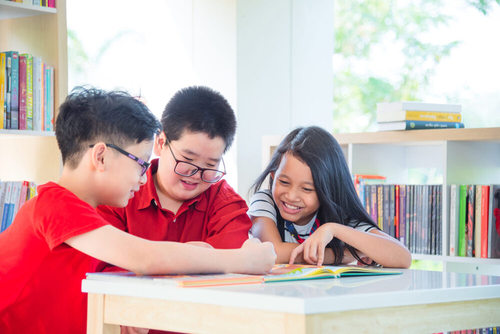 3 kids reading a book