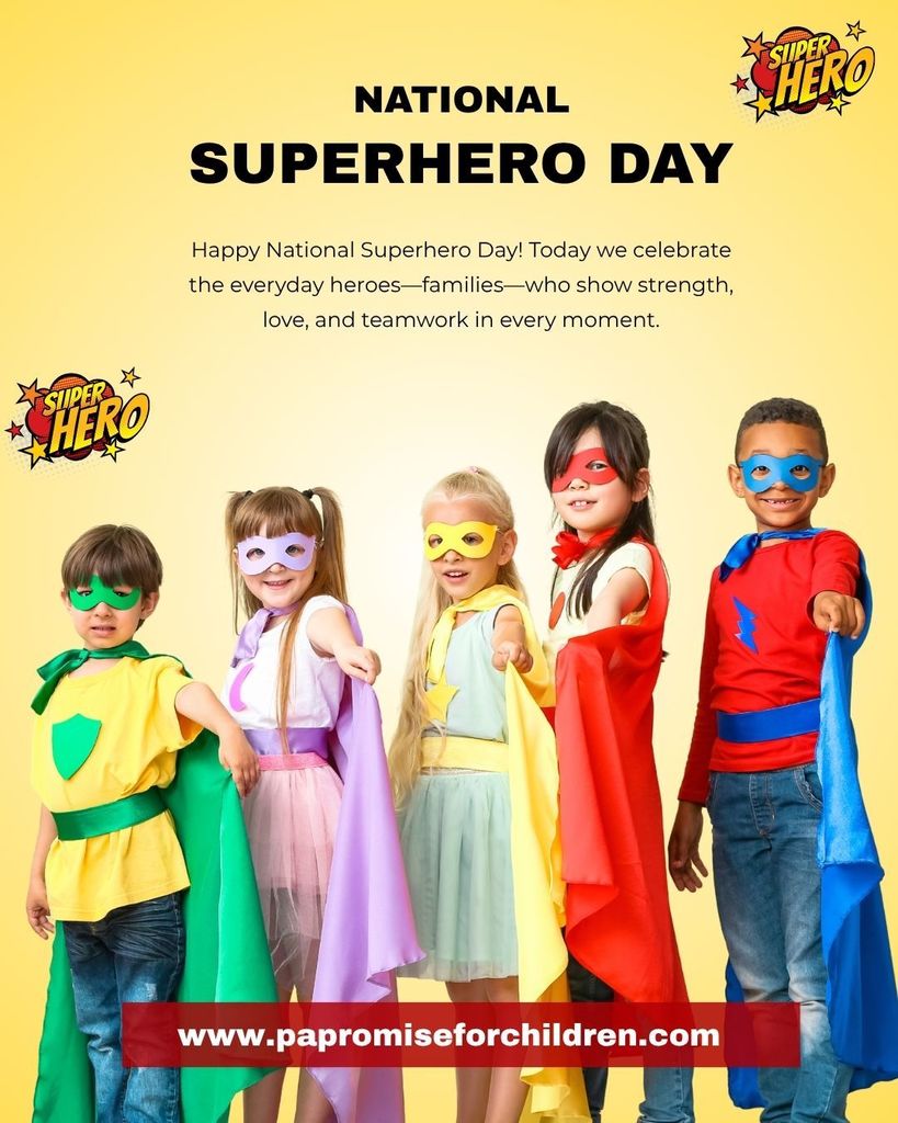 Seven children in superhero costumes stand in a row. A banner above them reads "NATIONAL SUPERHERO DAY" and "Happy National Superhero Day!" with a website link below.
