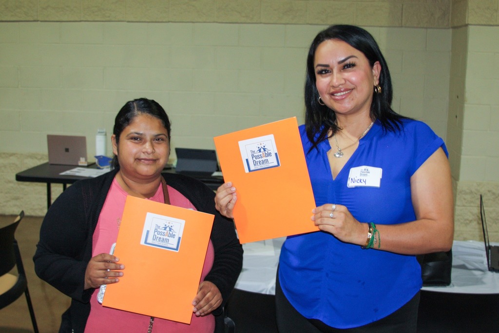 adult high school students posing for photo with folders in hand.