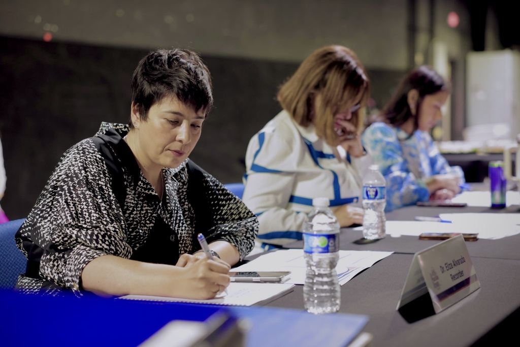 people writing at a conference desk