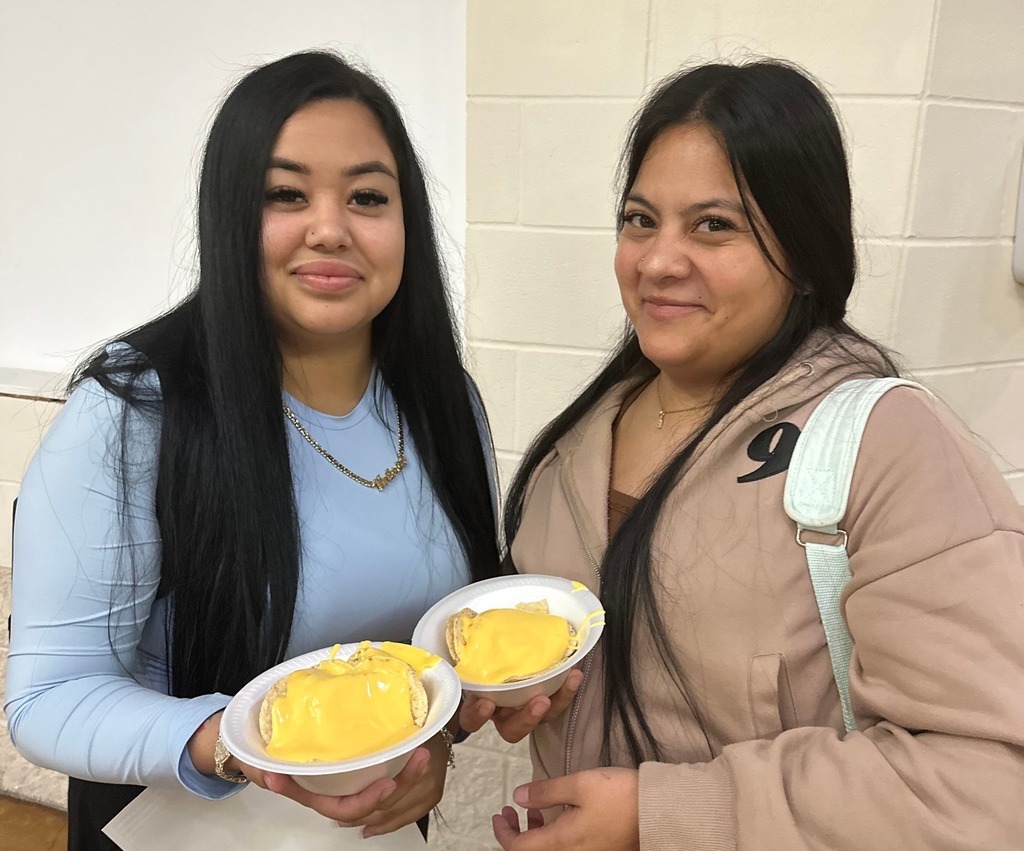 two students posing with nacho meal