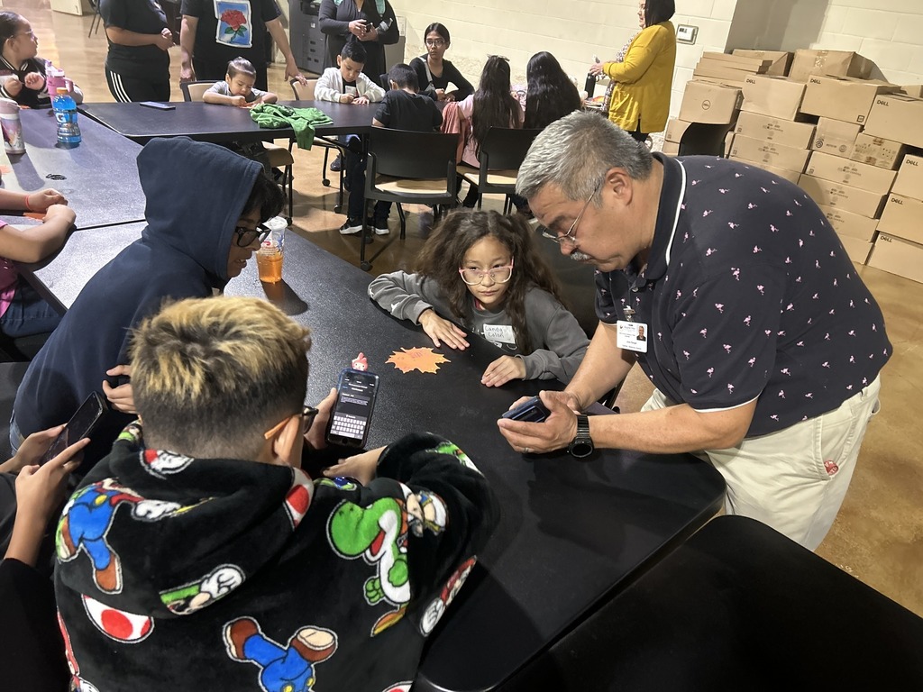 kids viewing a phone around a table