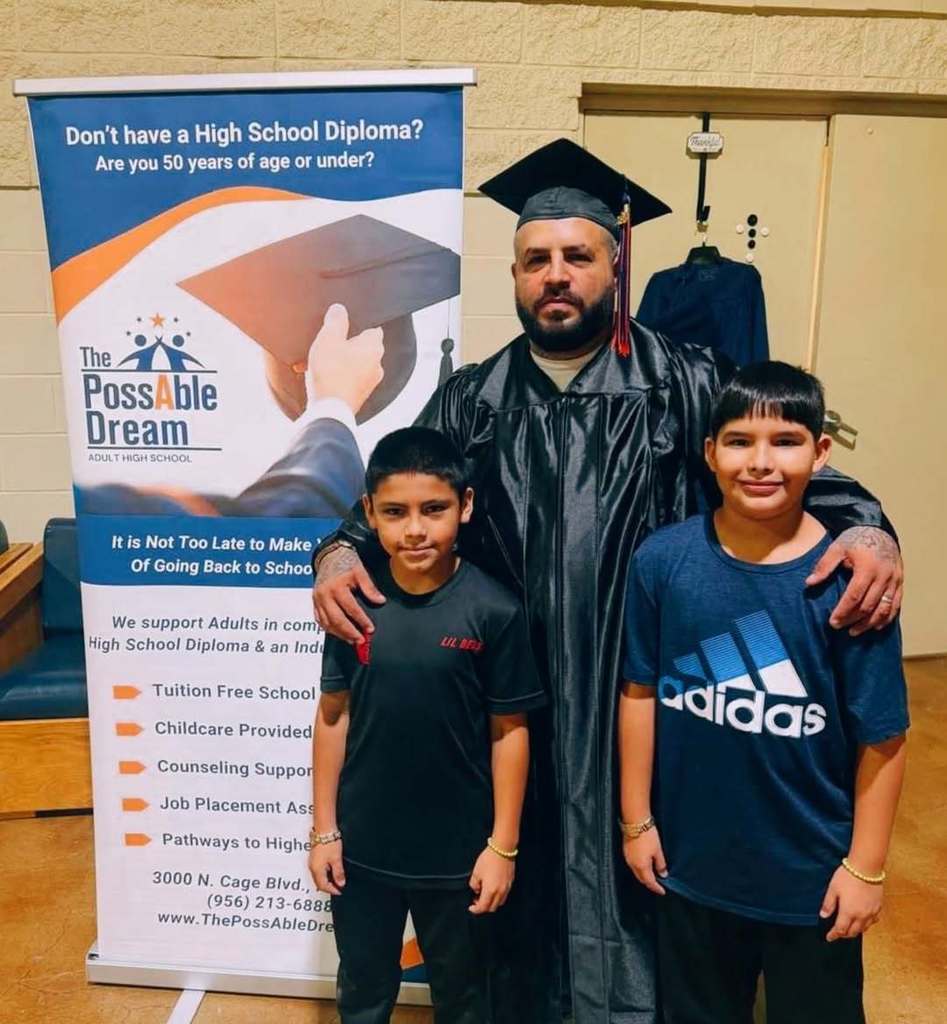 Graduate posing with two children