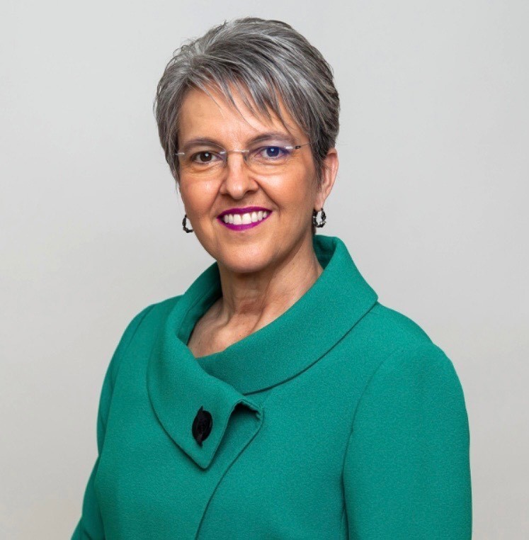 headshot of Charity Reedy Warigon. She has short gray hair and is wearing a green top.
