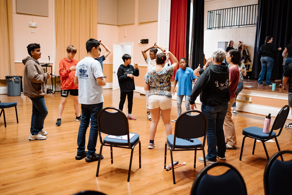 students standing in a circle practicing improv with a wayne theatre leader