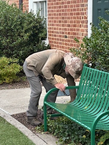 A VSDB staff member is looking under a bench 