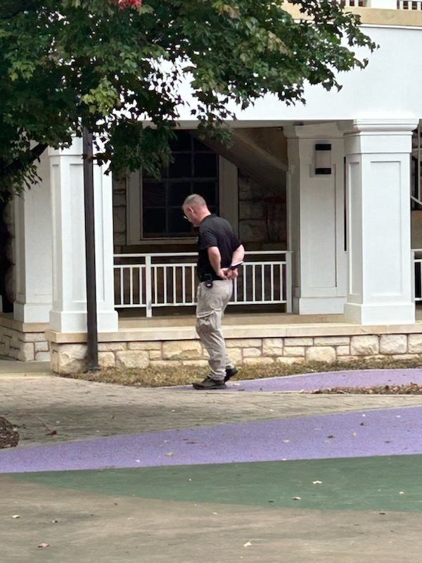 A VSDB staff member is looking in some grass
