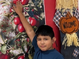 a student is inside and touching an apple from a apple orchard background