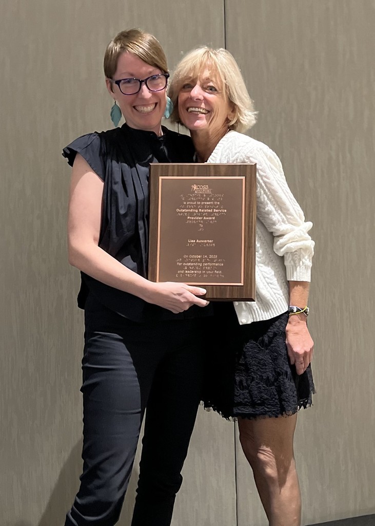 Lindsay Burris standing with Lisa Auwarter holding a plaque recognizing Lisa as the Service Provider of the Year