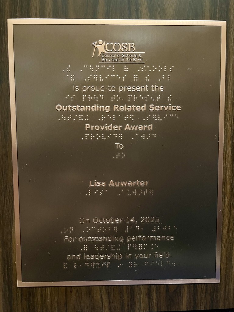 Copper colored plaque mounted on wood that reads in both print and braille: COSB Council of Schools & Services for the Blind is proud to present the Outstanding Related Service Provider Award To Lisa Auwarter on October 14, 2025 for outstanding performance and leadership in your fie