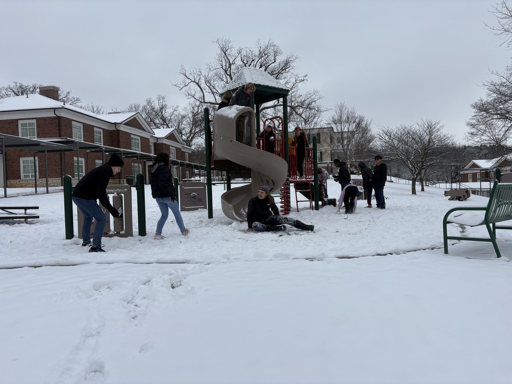 kids are playing at a snow filled playground