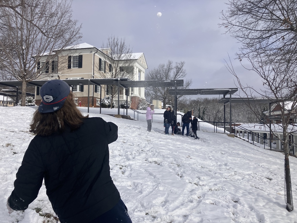 A student throws snow towards other students 