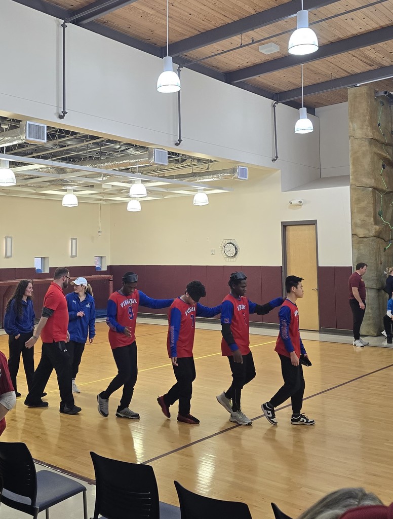 the VSDB boys team lines up across the floor and they walk with their hands on each others shoulders 