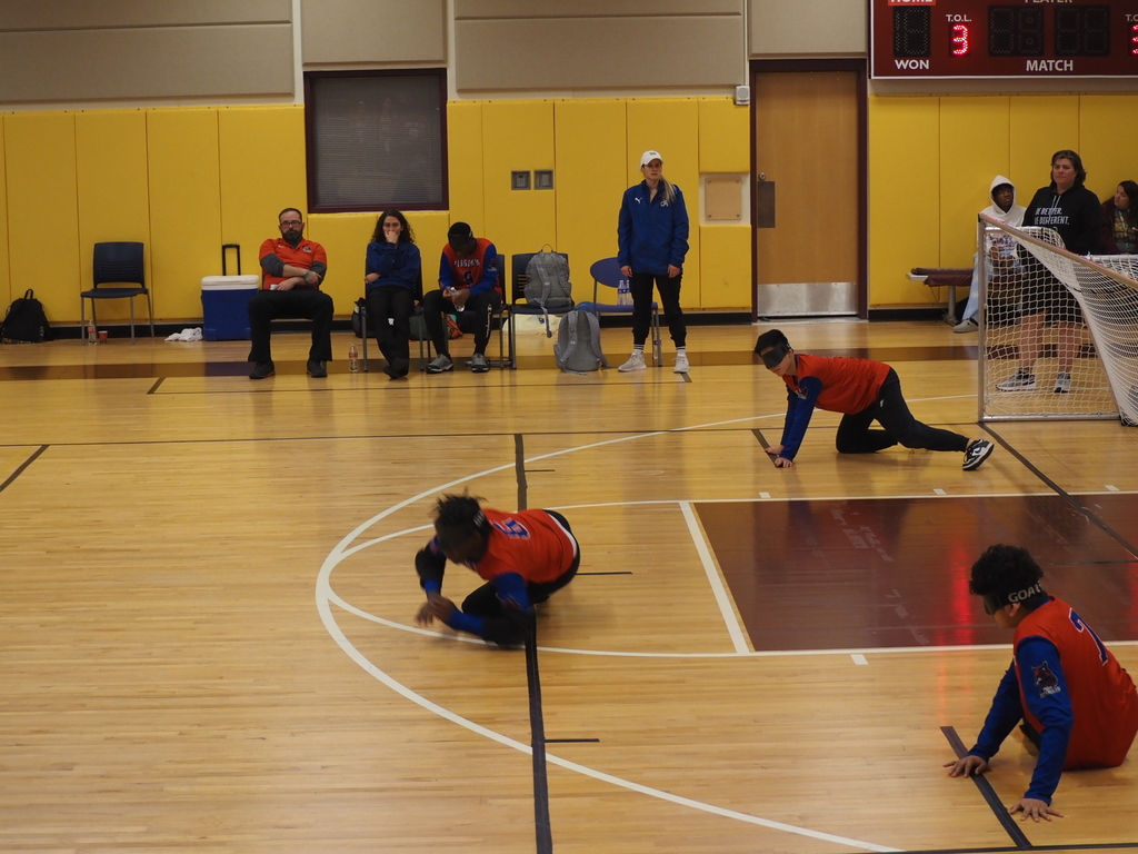 Three VSDB students face off on the floor in front of the goal 