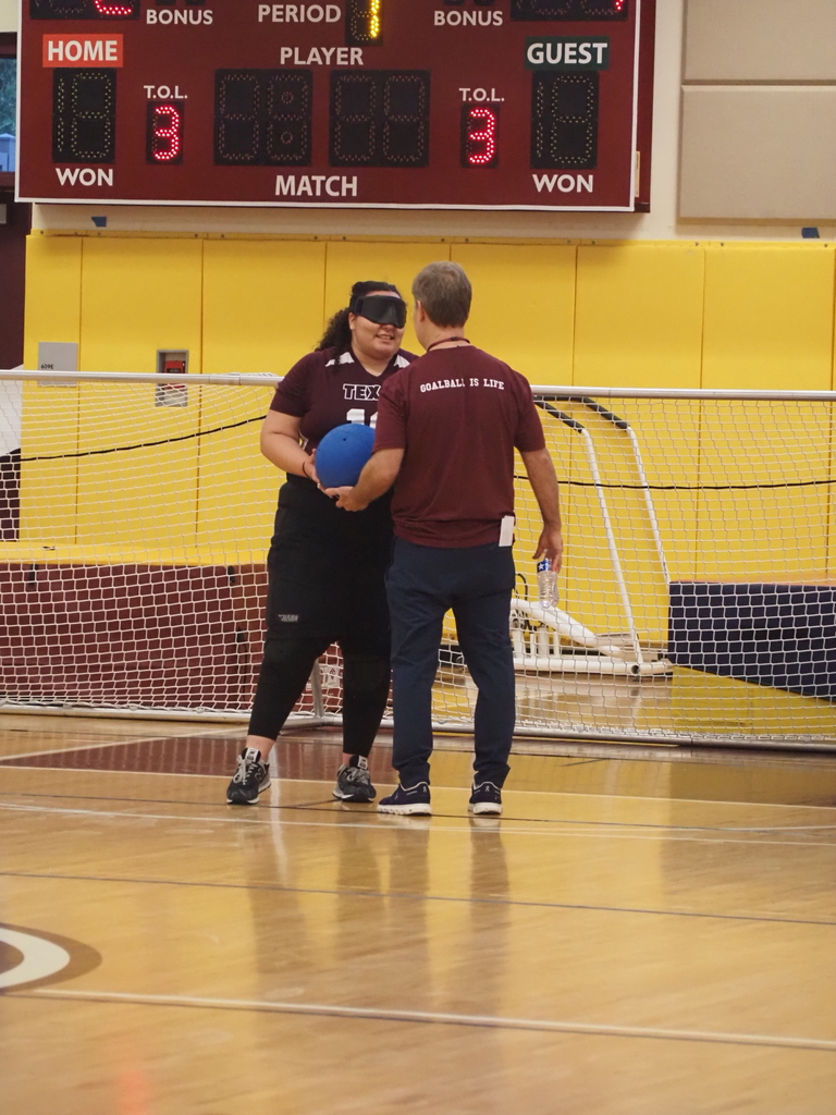 An adult hands the ball to our VSDB student 