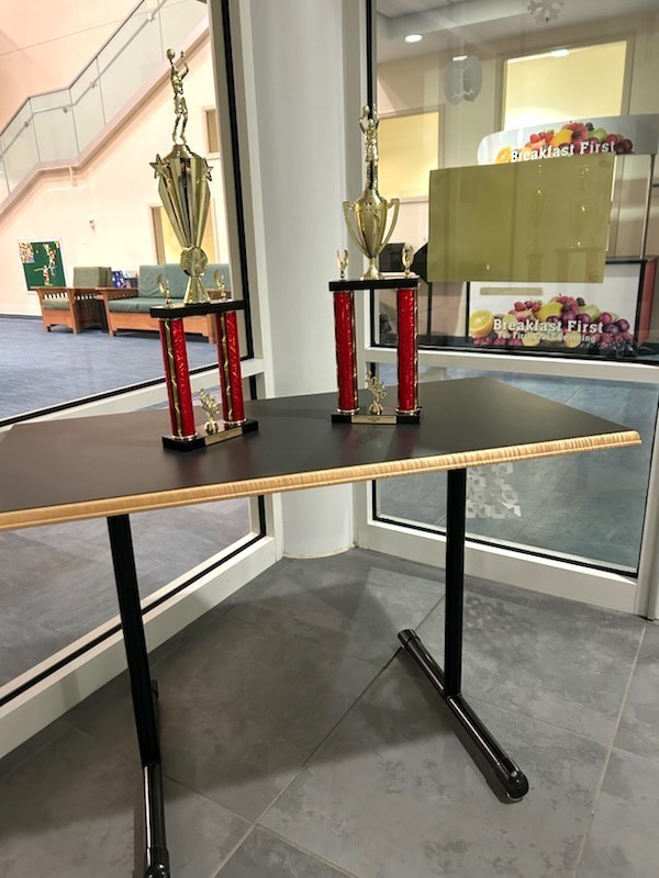 Two trophies are on a table in the lobby