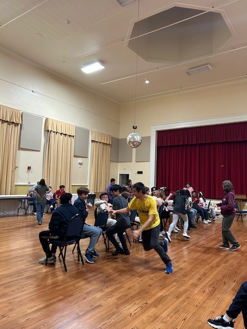 students racing to find a seat in a game of musical chairs