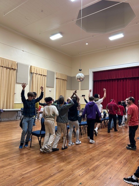 students walking around chairs for a game of musical chairs
