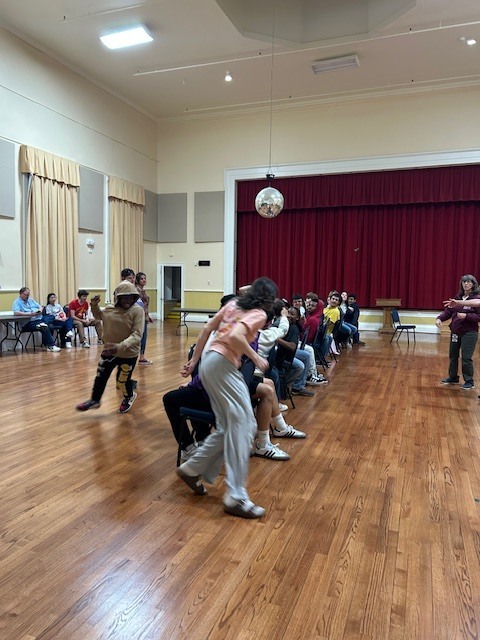 students racing to find a seat during a game of musical chairs