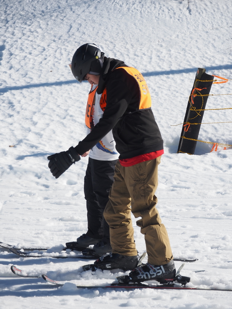 A blind skier is looking toward the ground