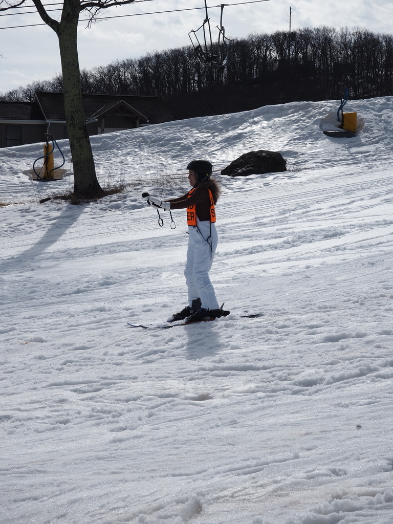 a blind skier is skiing down the mountainside on a shallow slope.