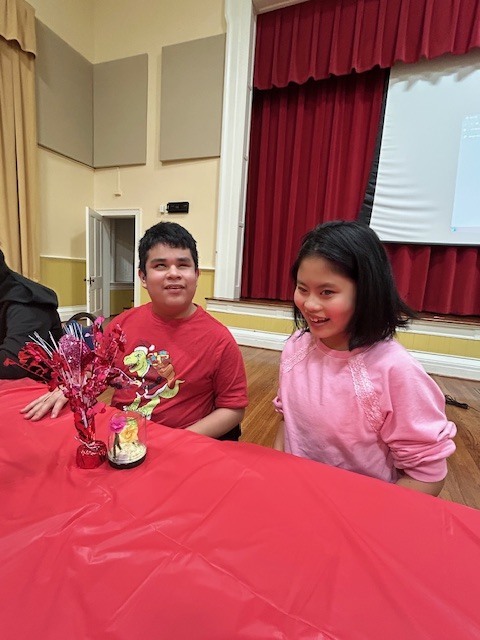 male and female student sitting at a table and smiling