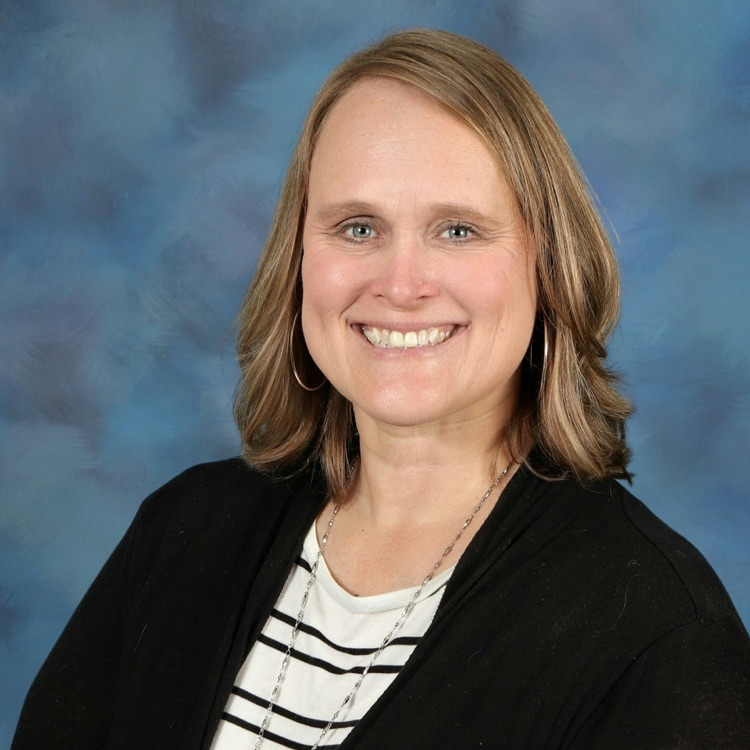 Headshot of Julie Conner wearing a black sweater over a black and white striped shirt