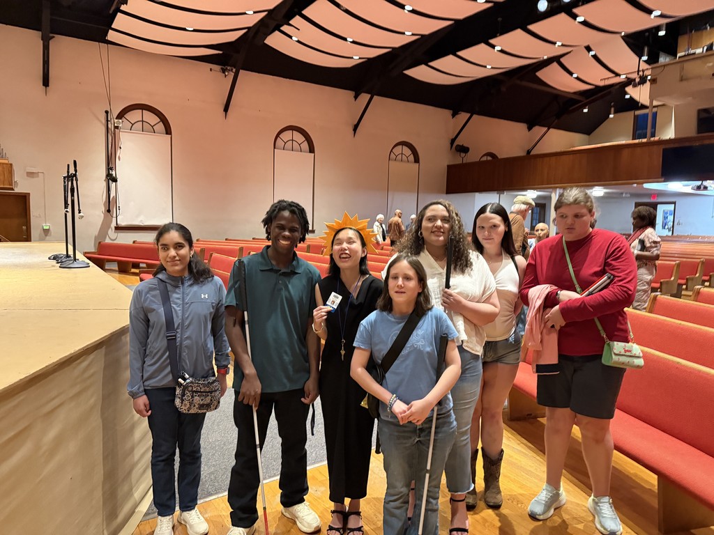 a group of VSDB students with VSDB Alum and EMU student, Carina. Left to right - Gladys, Morris. Carina, Charlotte, Amiyah, Mikayla, and Macy. Carina has a big smile and is wearing a sunshine headband. 