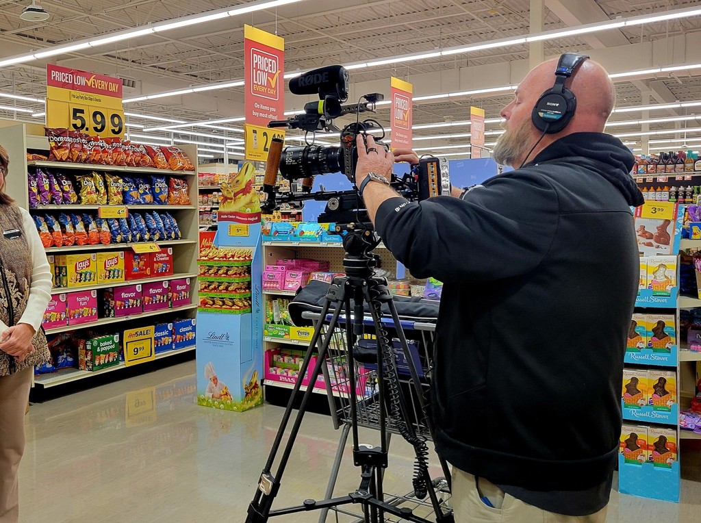 A sliver of a person is shown standing in a grocery store while the camerman is recording them.