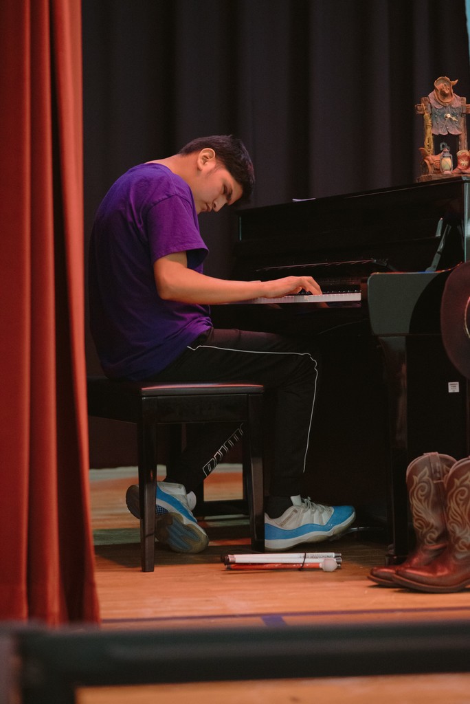 A student is playing at the piano.