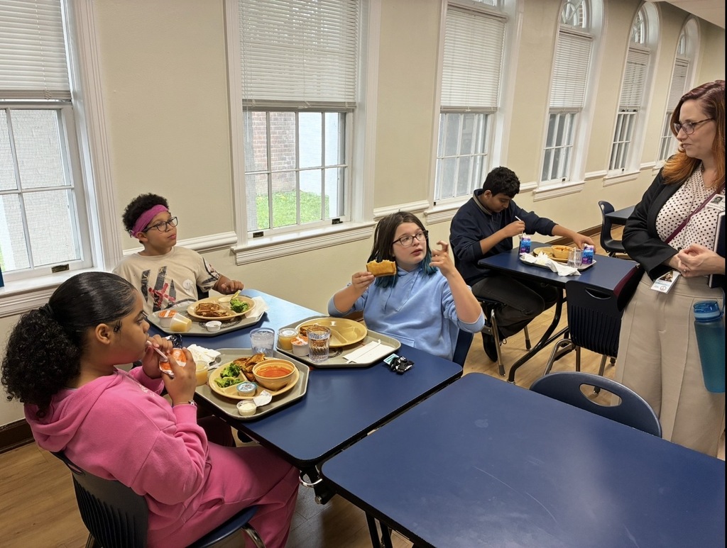 Dr. Maxlow at a table with 5th grade students while they eat lunch and talk with her