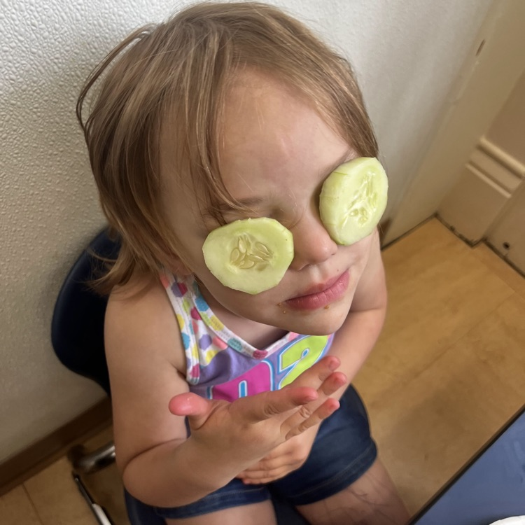 young girl with cucumbers on her eyes