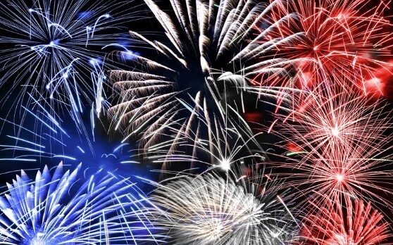 Red, Blue, and White fireworks are in the night sky