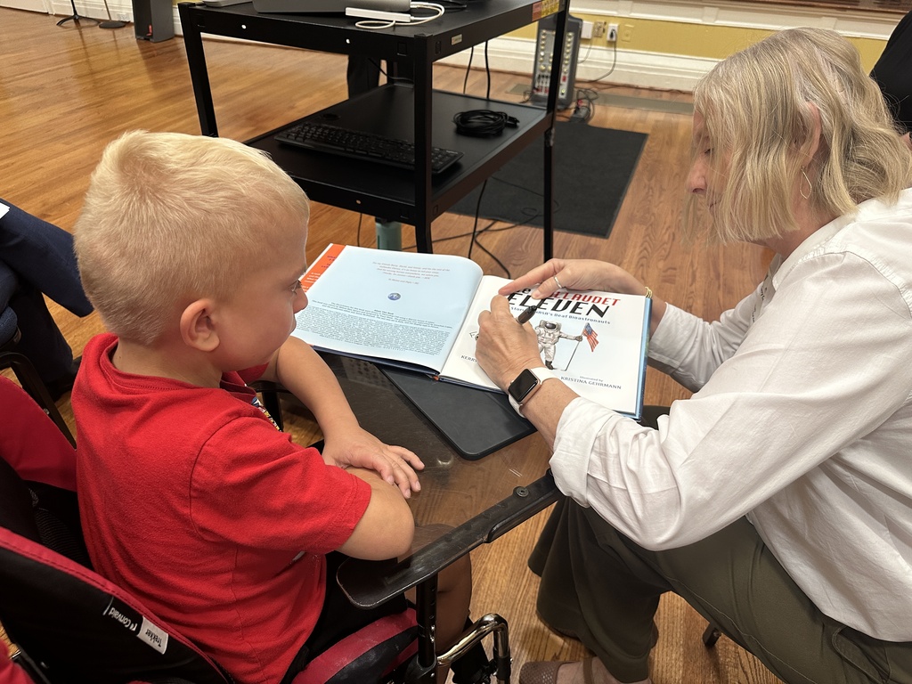 Kerry signing a book for a young boy