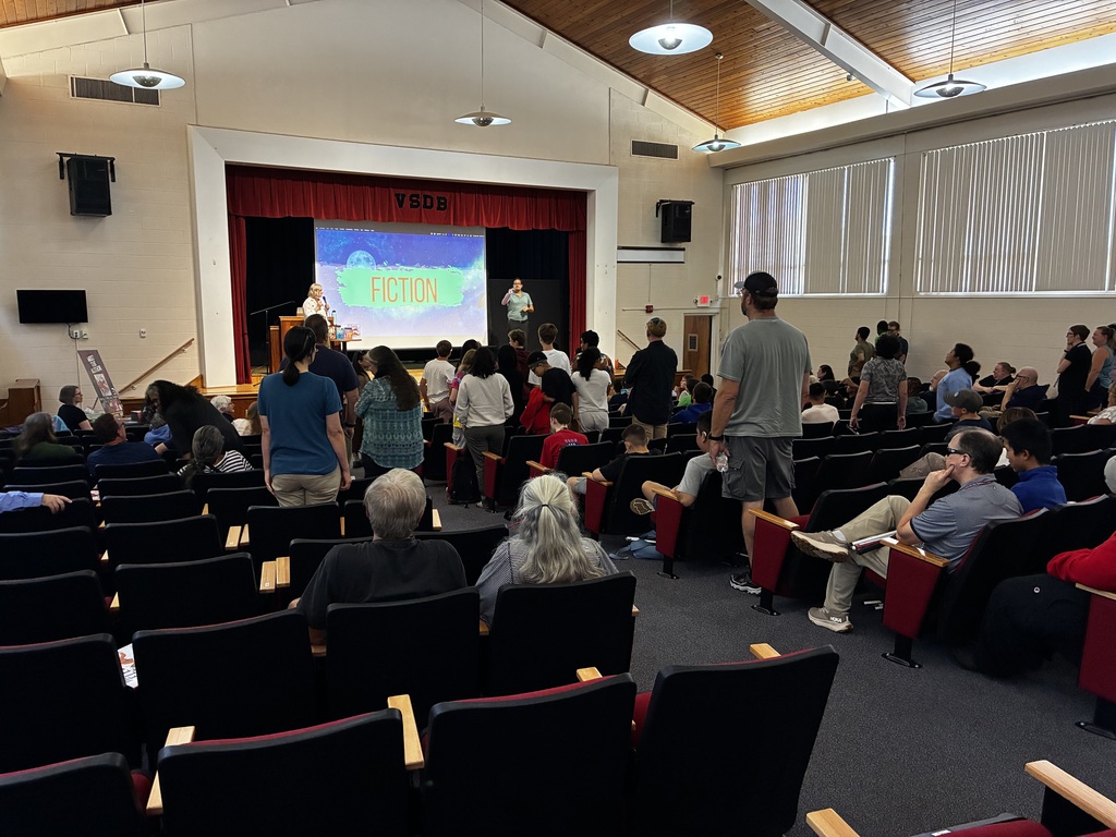 many people in the auditorium during Kerry's presentation. some people are standing, indicating they are still "in" during Kerry's trivia contest.