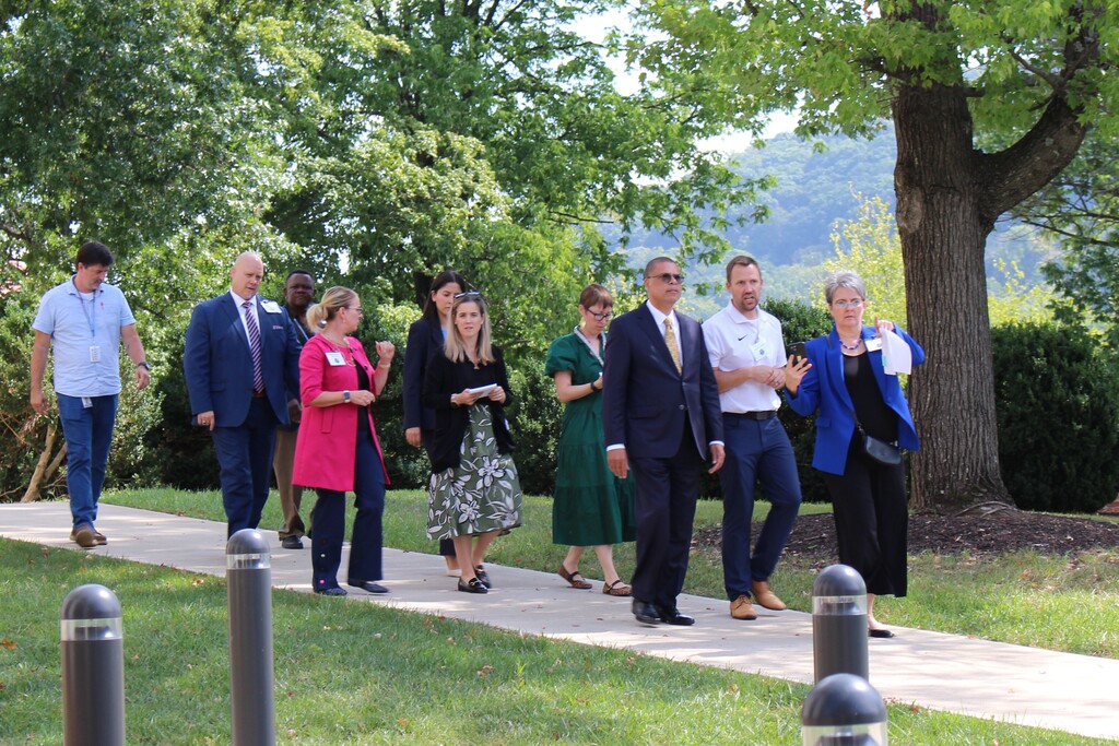 A large group is walking outside, they are being led across campus. You can see the mountains in the background. 