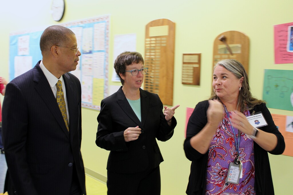 Dr. Jeffrey O. Smith is walking through the school halls with Jessica McMahon the Deaf Dept. Principal, and an interpreter. 