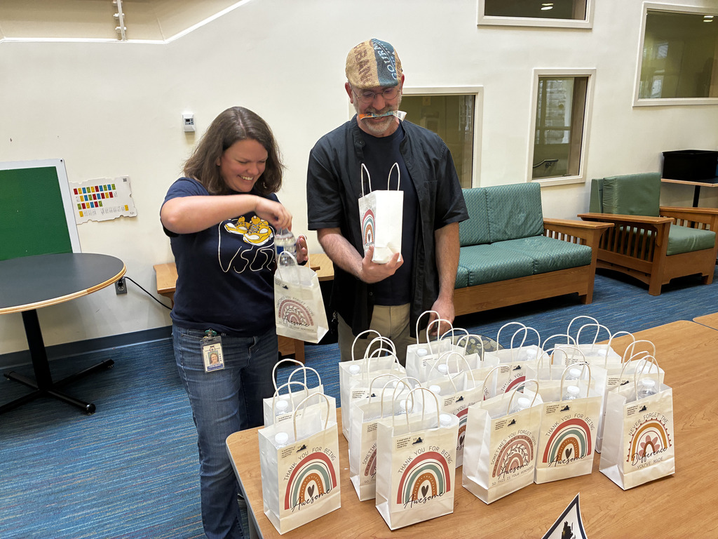 two staff looking through their goodie bags and smiling at the contents