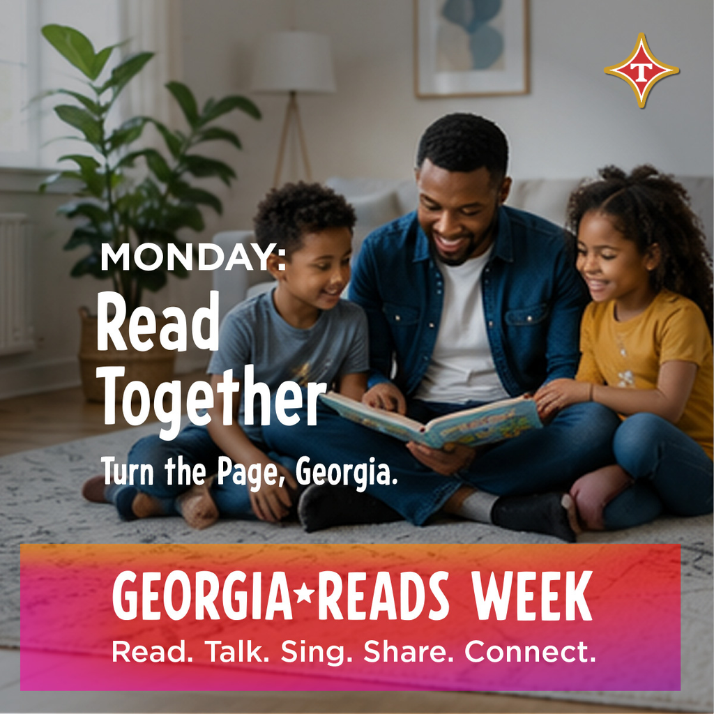 A man and two children sit on a rug. The man reads from a book to the children.