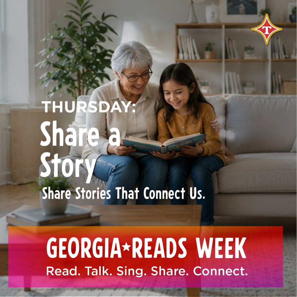 Older woman and young girl sit on a sofa, reading a book together. Background includes a plant and bookshelf.