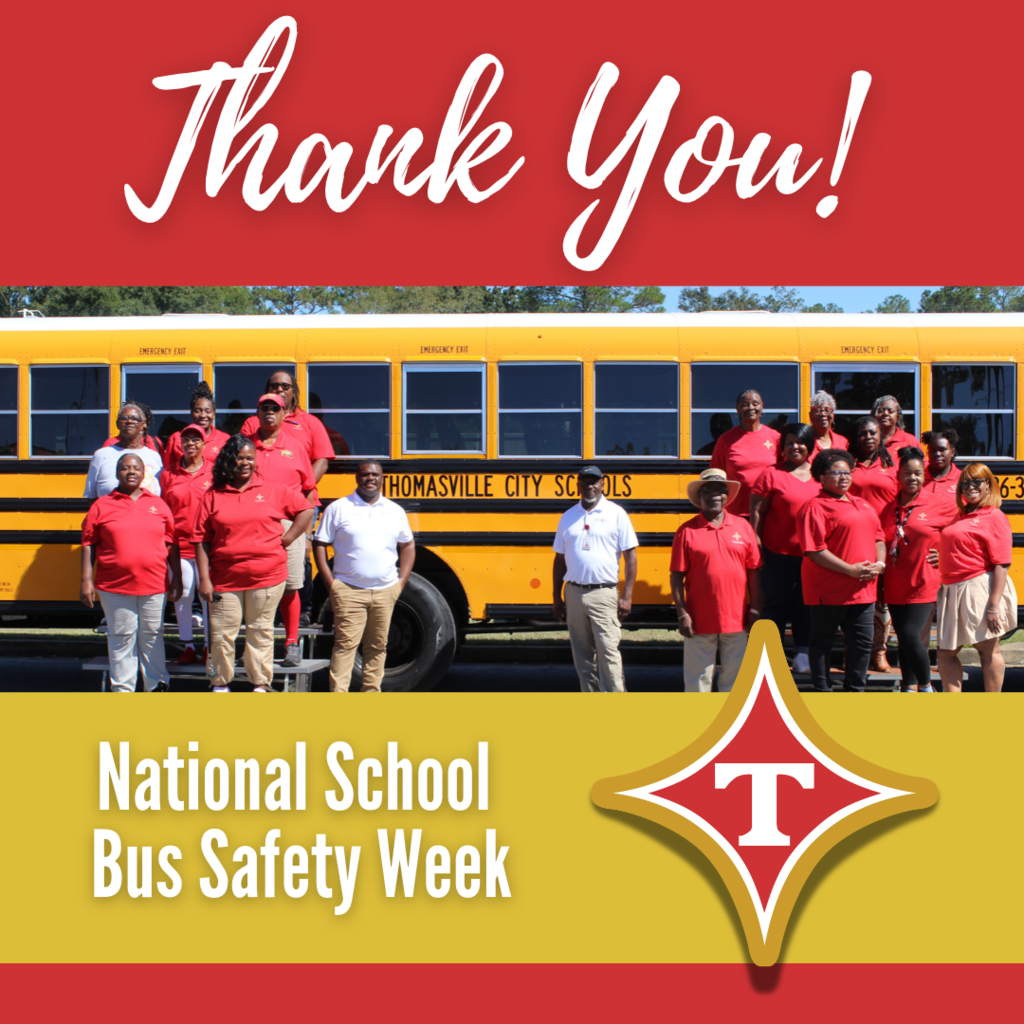 A group of people in red shirts stand in front of a yellow school bus.